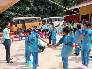 Group of child with blue tshirt holding hand outside the school