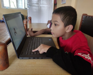 A children trying to learn computer and watching a screen.